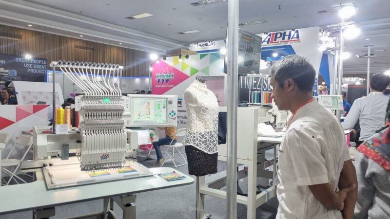Seorang pria sedang memantau mesin bordir otomatis (foto : Jppn)